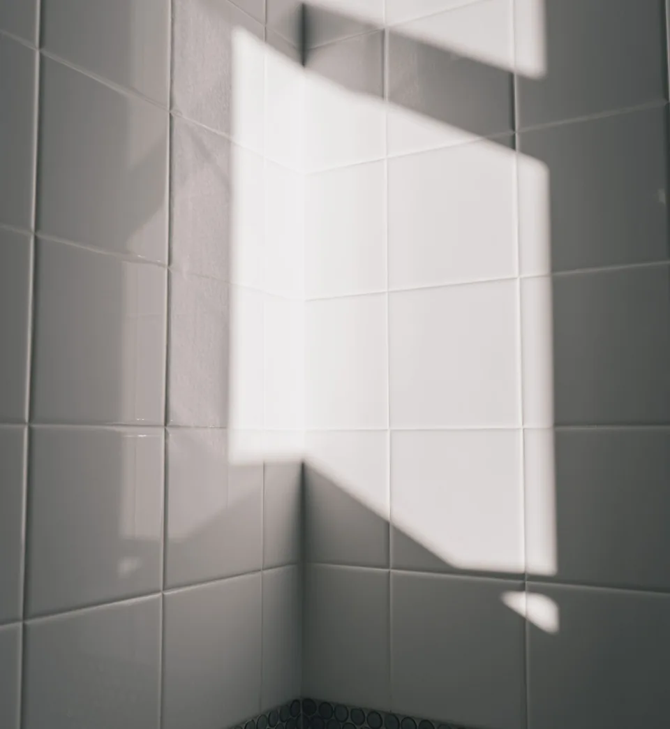 Daylight casts quiet geometric shadows on light tiles.